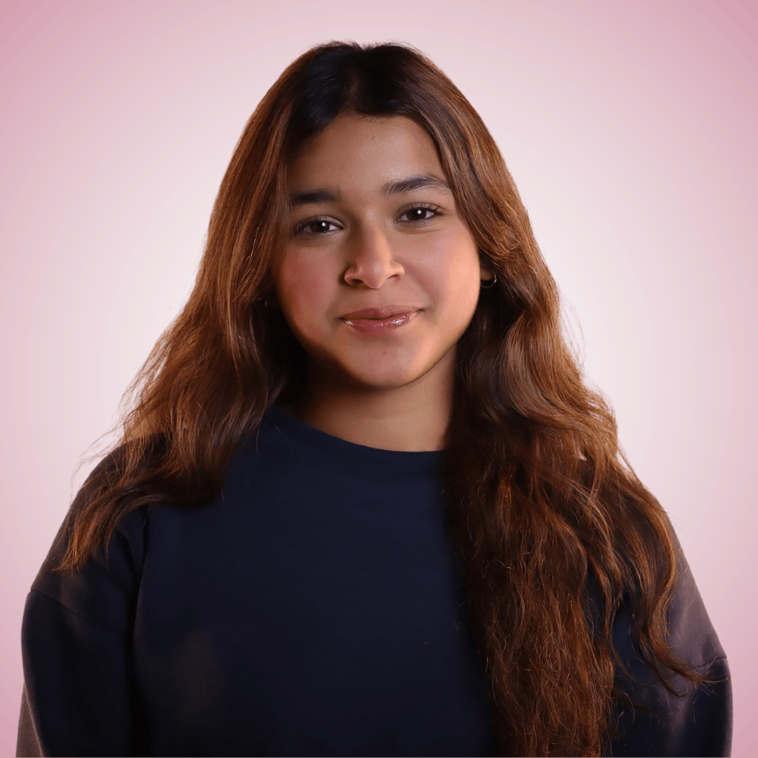 Headshot of Jia Rastogi with a light pink background colour